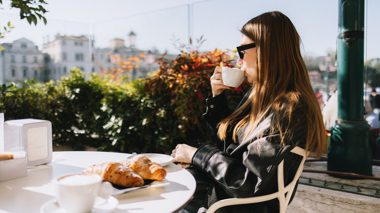 Une femme buvant du café au petit déjeuner à Venise