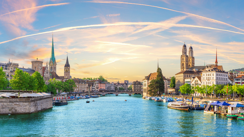 Downtown Zurich au coucher du soleil avec des églises célèbres et des ponts de rivière