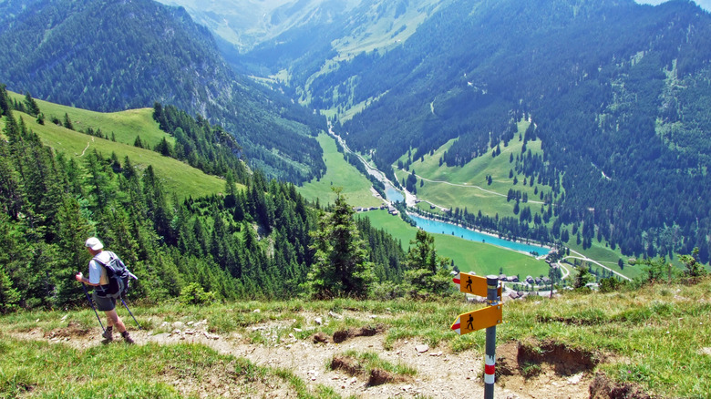 Randonneur sur un sentier dans les montagnes au-dessus du lac bleu