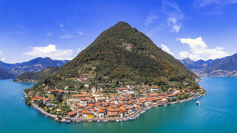 Village pittoresque niché sur une île montagneuse luxuriante, entourée par les eaux du lac d'Iseo, près de Brescia