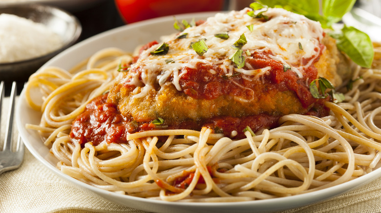 Une assiette de poulet parmigiana sur spaghetti