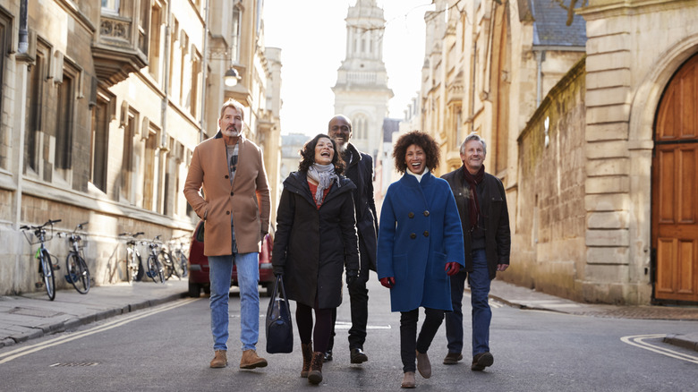 Touristes marchant ensemble dans une rue européenne à l’architecture historique