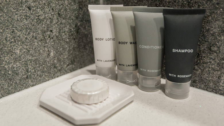 Articles de toilette en bouteille et un pain de savon dans un hôtel
