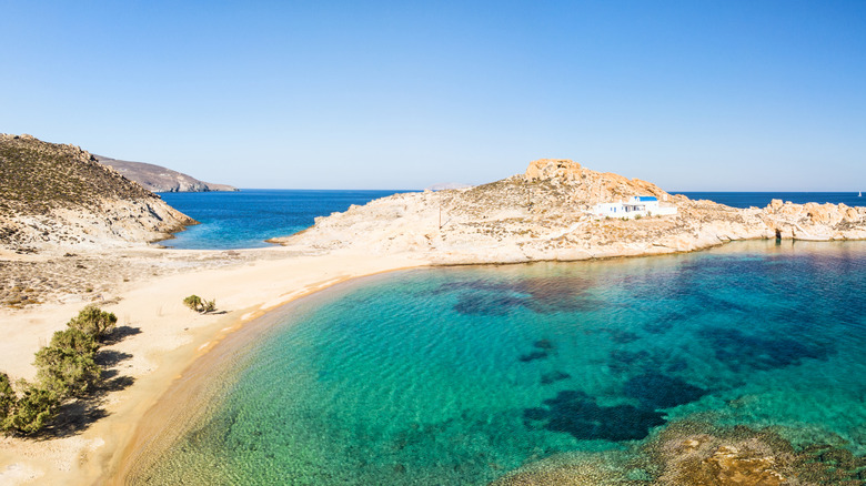 L'eau turquoise parcourt l'isthme de sable avec l'église de la plage d'Agios Sostis à Serifos