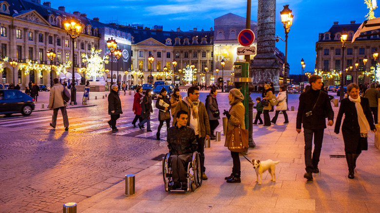 Homme en fauteuil roulant sur la place de la ville de Paris, France