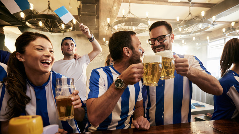 Fans de bière portant des bandes rayées bleues et blanches dans un pub