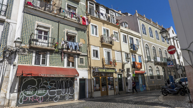 Des magasins et des cafés se trouvent sous des appartements dans une rue pavée d'Anjos.
