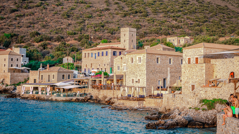 les gens profitent de la vue et du soleil au village de Limeni en Grèce