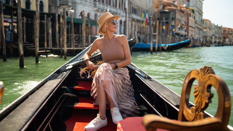 Une femme assise sur une gondole à Venise, Italie