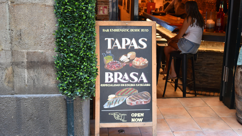 un tableau noir affichant les types de petites bouchées disponibles dans un bar à tapas