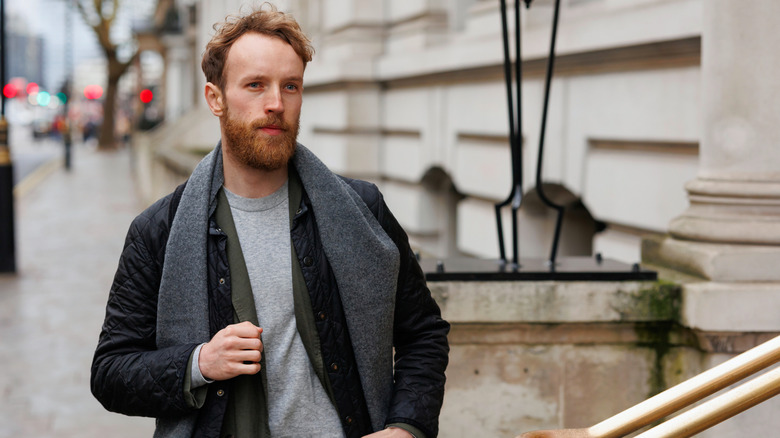 Homme en manteau et écharpe dans une rue de Londres, Angleterre
