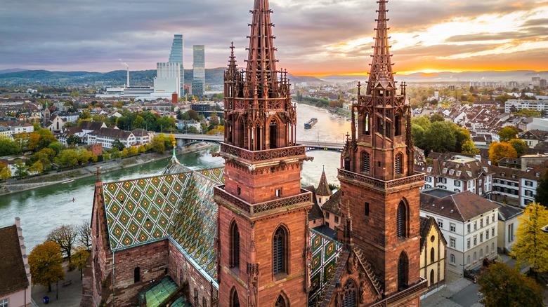 Une vue sur la cathédrale de Bâle-Münster mettant en valeur ses flèches jumelles avec la rivière et le paysage urbain au-delà