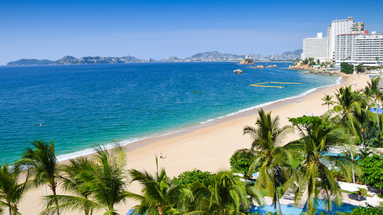 Une vaste plage de sable blanc et l'océan Pacifique à Acapulco, au Mexique