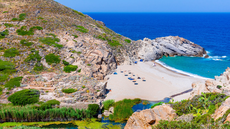 Une plage de sable fin entre des falaises parsemées de verdure luxuriante