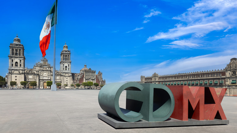 Le Zócalo de Mexico, montrant un panneau indiquant "CDMX "et un drapeau mexicain en arrière-plan
