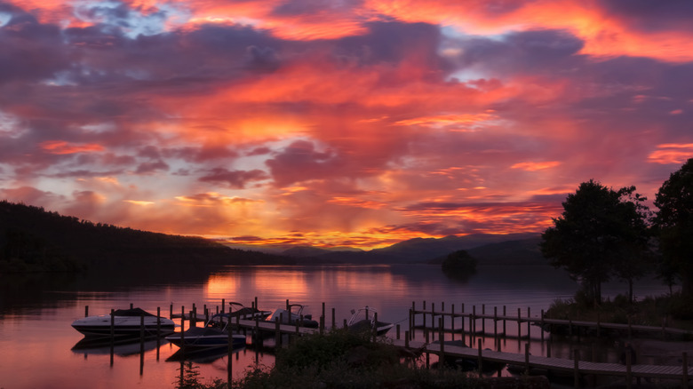 Coucher de soleil sur le lac avec une petite jetée et des bateaux