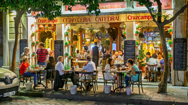 Les gens sont assis devant un bar à tapas à Séville, Espagne