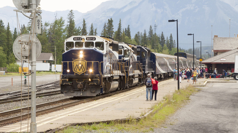Passagers attendant à côté du train Rocky Mountaineer à Banff, Canada