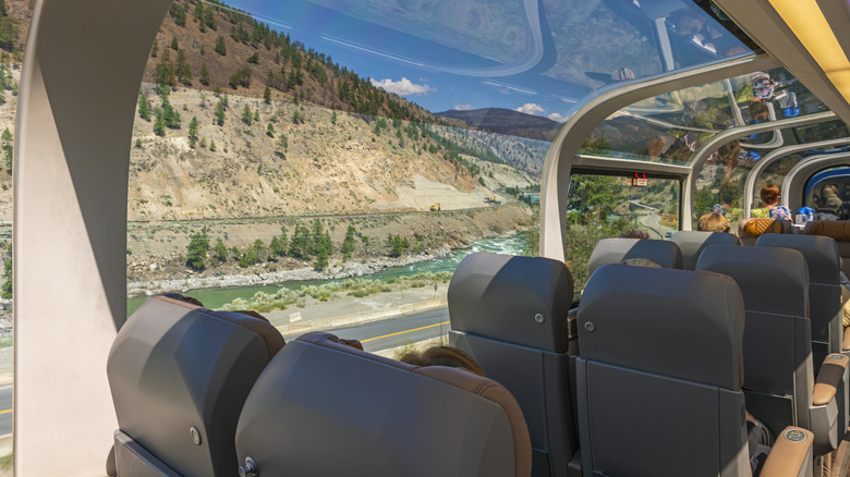 L'intérieur du train Rocky Mountaineer avec des fenêtres en verre révélant un paysage de montagne