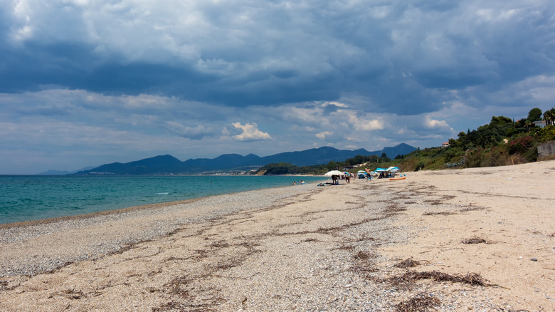 Les rives sablonneuses de la plage de Monolithi en Grèce encadrées par des montagnes au loin
