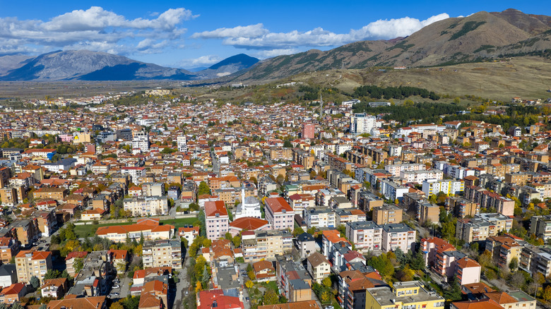 Vue aérienne de Korca, Albanie, pleine de bâtiments, courant vers des montagnes chauves en arrière-plan