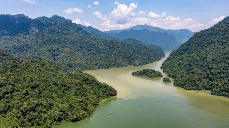 Rivière verte serpentant autour des îlots et des montagnes des deux côtés