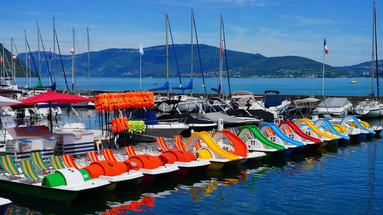 Voiliers, pédalos et bateaux à moteur alignés sur un quai au Lac du Bourget en France