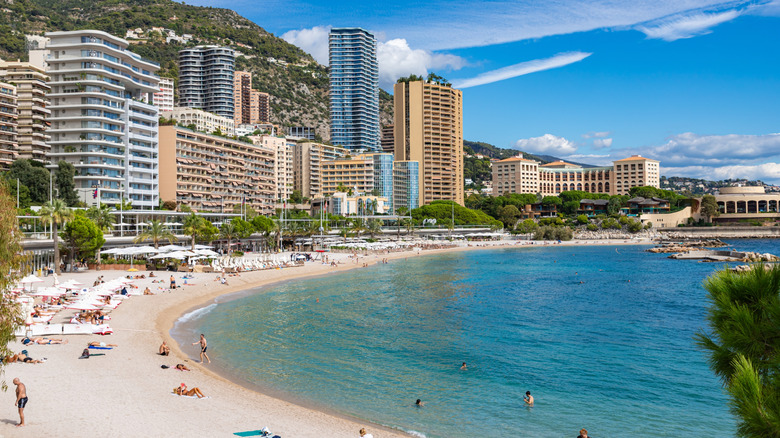 Les gens bronzent et nagent sur la plage du Larvotto à Monaco par une journée ensoleillée