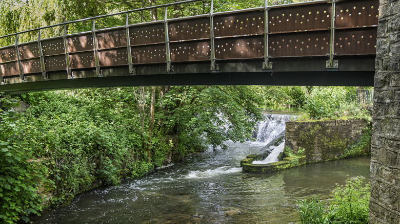 Un déversoir et une passerelle au-dessus de la rivière Chew à Keynsham au Royaume-Uni