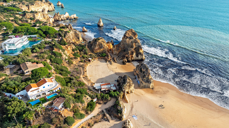 Vue aérienne des rochers et des maisons à praia Tres Irmaos près d'Alvor en Algarve Portugal