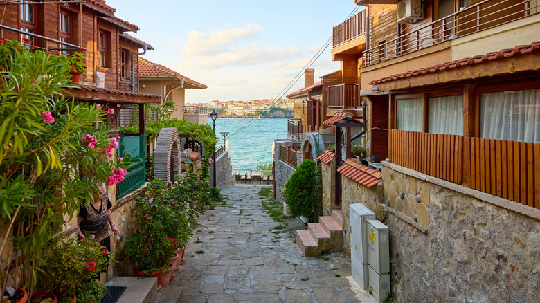 Allée pavée étroite dans la vieille ville de Sozopol avec la mer en arrière-plan