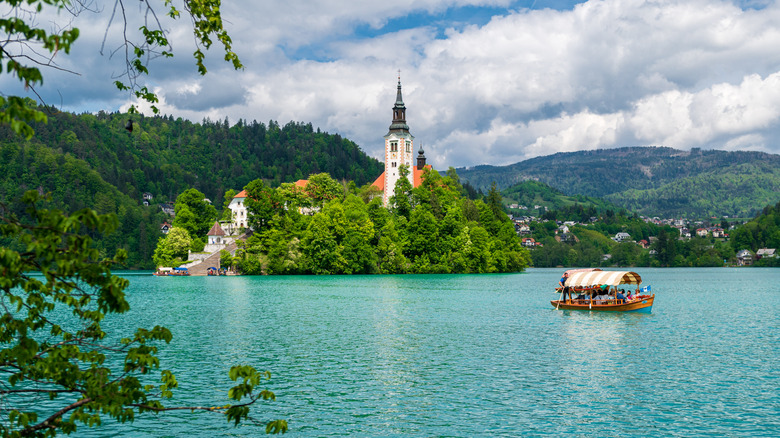 Un bateau pagaye sur le lac de Bled devant son île pittoresque en Slovénie