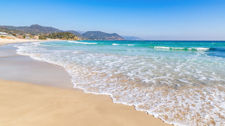 Mer turquoise clapotant sur le sable blanc sur une plage de Shimoda, Japon