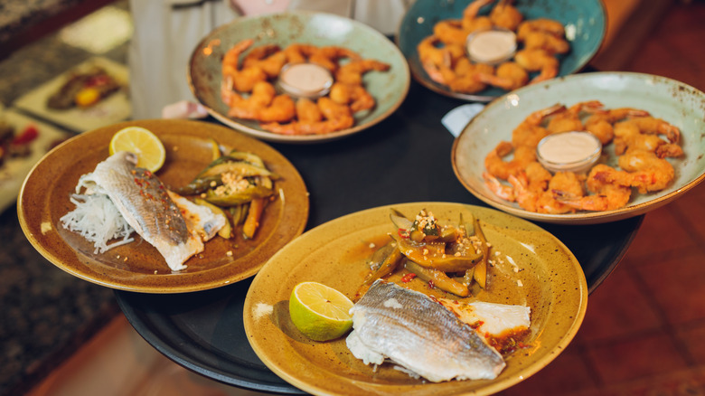 La serveuse porte un plateau de fruits de mer frais sur des assiettes