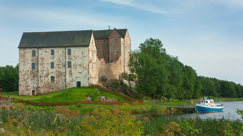 Château médiéval de Kastelholm surplombant un lac et un bateau
