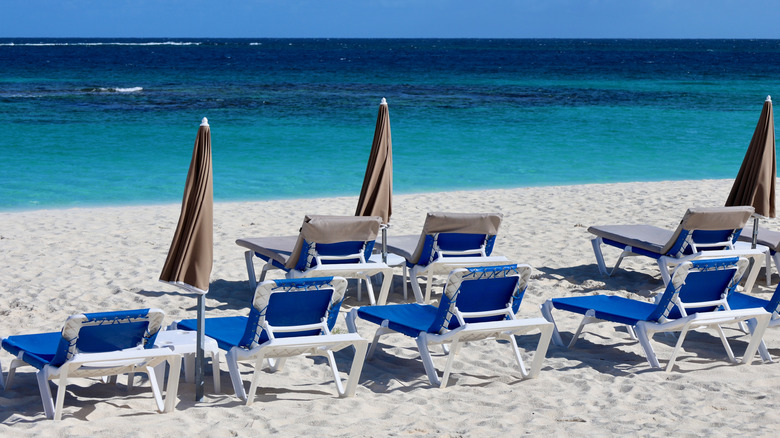 Chaises longues vides sur le sable blanc de la plage de Shoal Bay East.