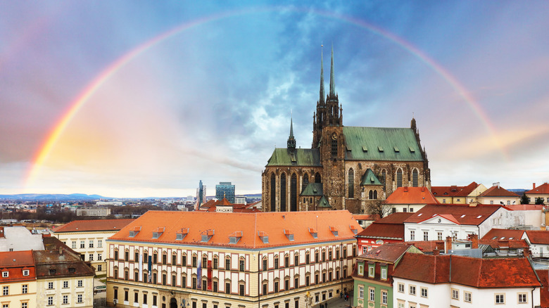 Un arc-en-ciel surplombe les bâtiments historiques et l'église en pierre de la ville de Brno, en République tchèque