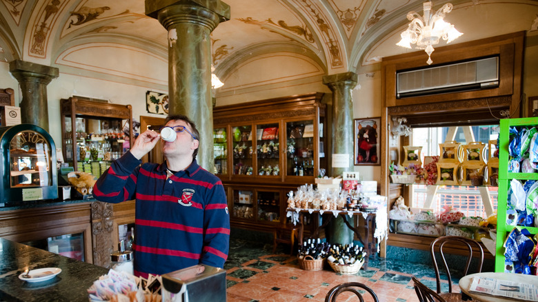 Un homme sirotant un expresso debout dans un café-bar italien