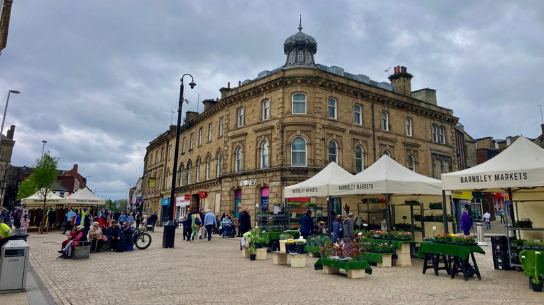 Les étals du marché extérieur de Barnsley avec un centre commercial couvert en arrière-plan