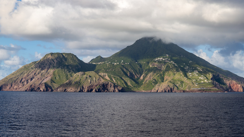 Le profil des montagnes de Saba s'élève au-dessus de la mer des Caraïbes, vue de loin depuis l'eau.