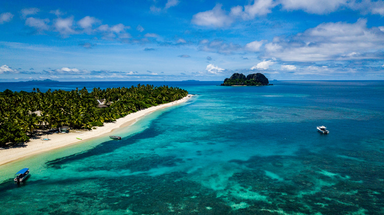 Vue aérienne des plages de l'île Vomo aux Fidji, avec des bateaux dans l'eau